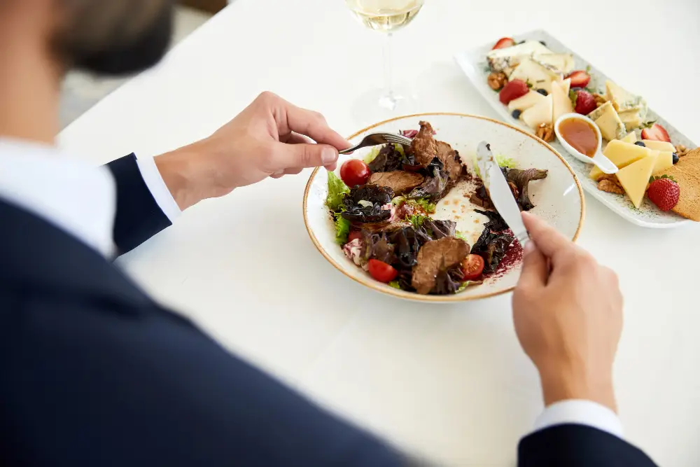 vista-superior-empresario-que-comiendo-ensalada-carne-almuerzo-negocios